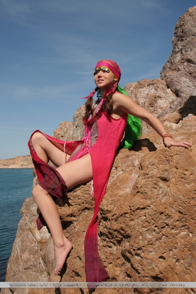 European teen Firebird A posing barefoot on rocky cliffs in revealing outfit