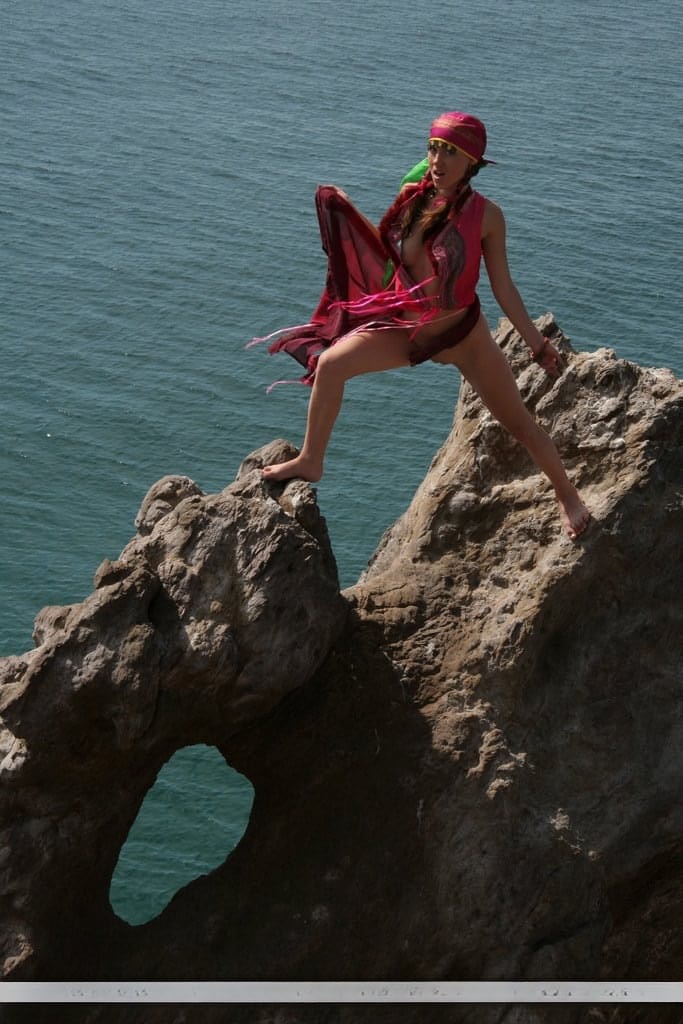 European teen Firebird A posing barefoot on rocky cliffs in revealing outfit