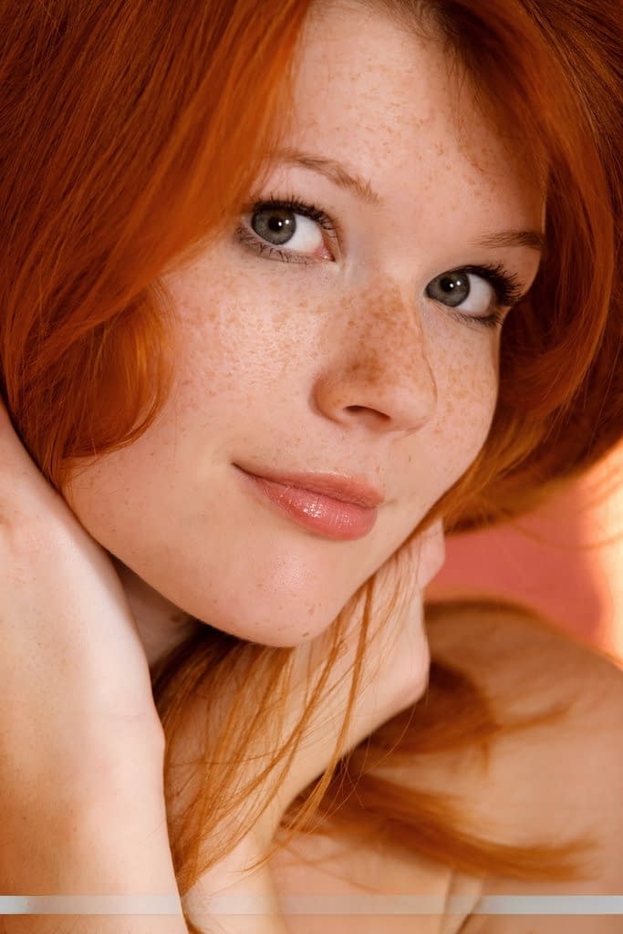 Redhead glamour model Mia Sollis posing in black lingerie in teasing manner