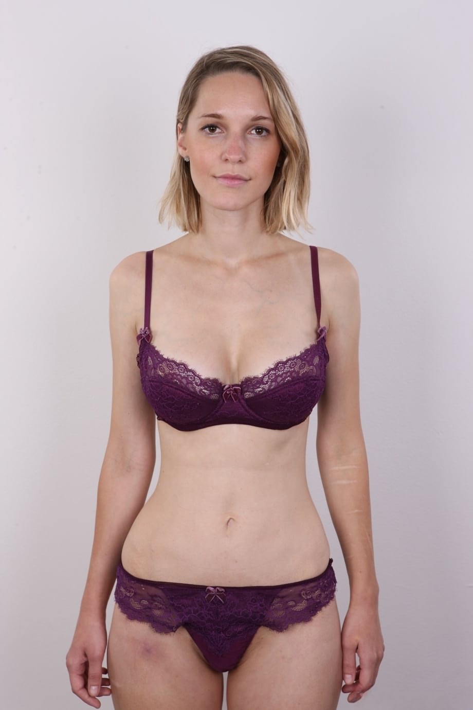 European female Tereza wears no expression while undressing for rent money