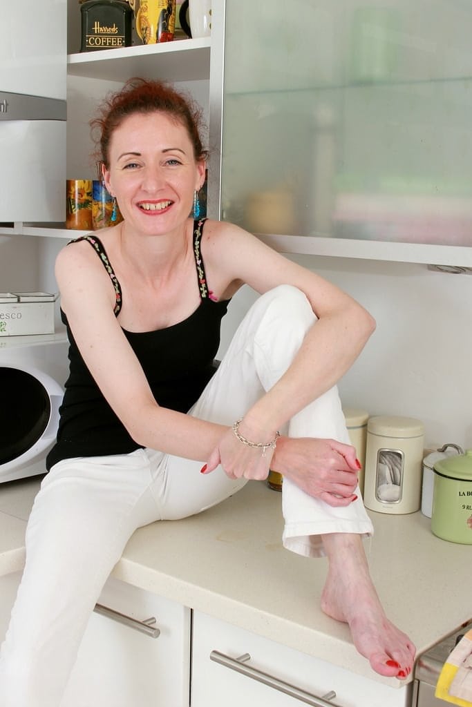 Skinny mature lady Scarlet Louise does a striptease in her kitchen