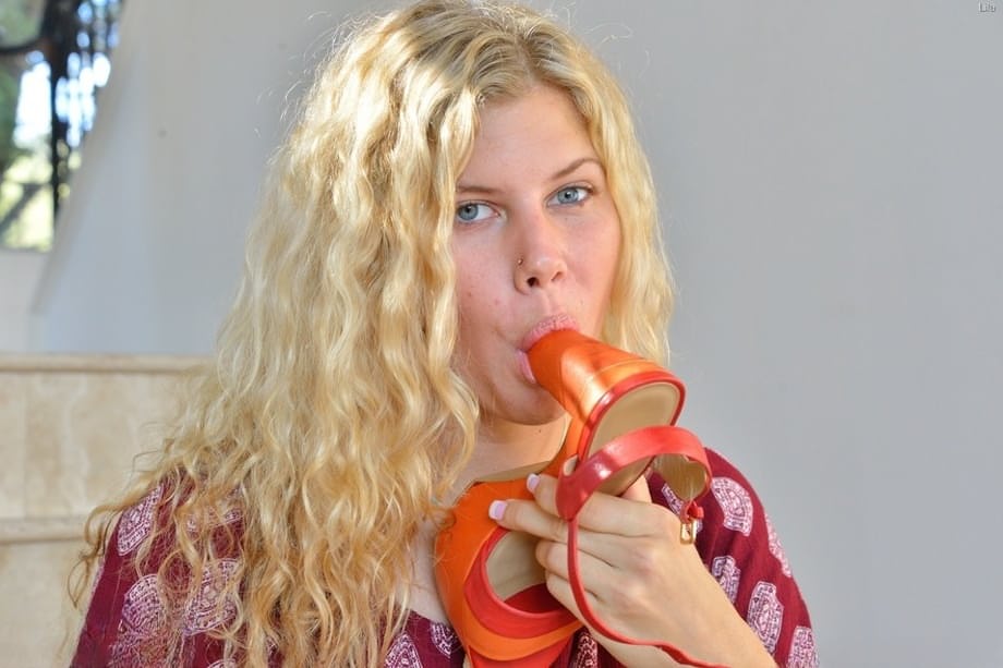 Natural blonde with wavy hair shows off her flexibility while doing yoga
