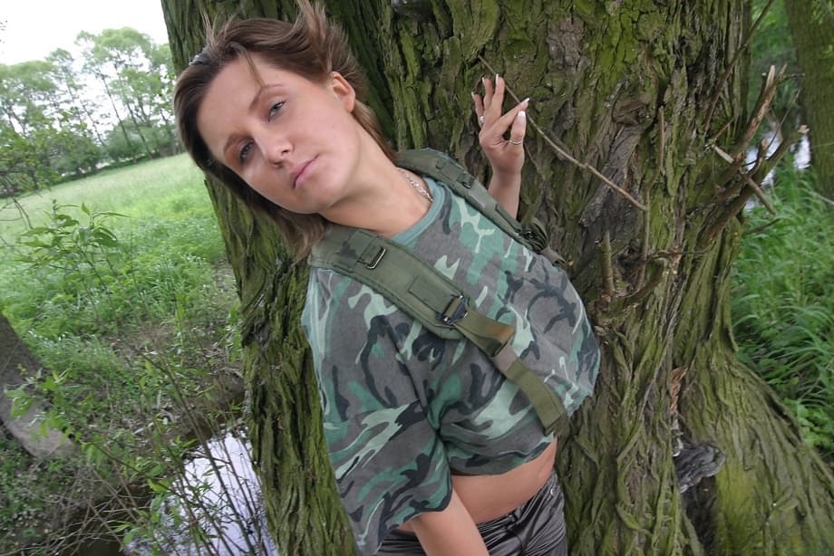 Solo girl Lea Ticia releases her huge tits from military fatigues under a tree