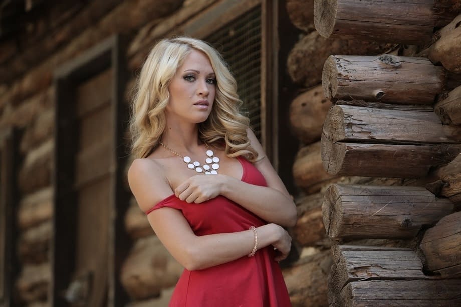 Bare legged blonde Shannyn Xo flashes upskirt panties in front of a log cabin