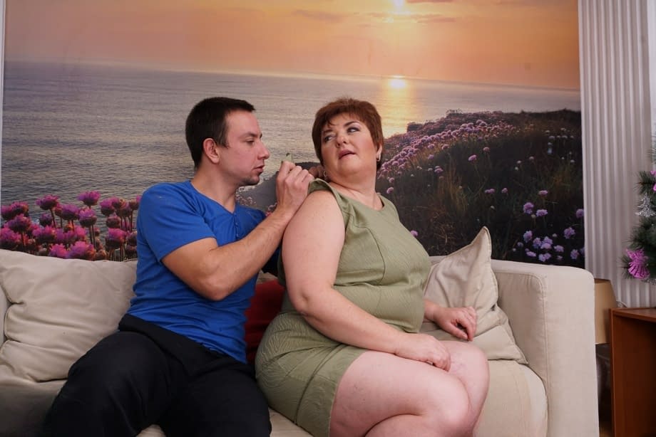 Sexy mature BBW bares her great big tits for her young boy toy to suck on