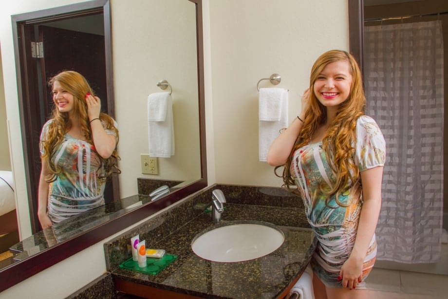 Bug and busty Amanda Love playing with her huge boobs in the bathroom mirror