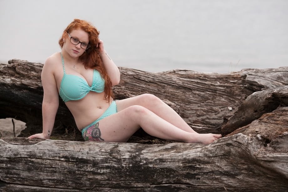 Sexy plump redhead Kaycee Barnes posing naked outdoors wearing glasses