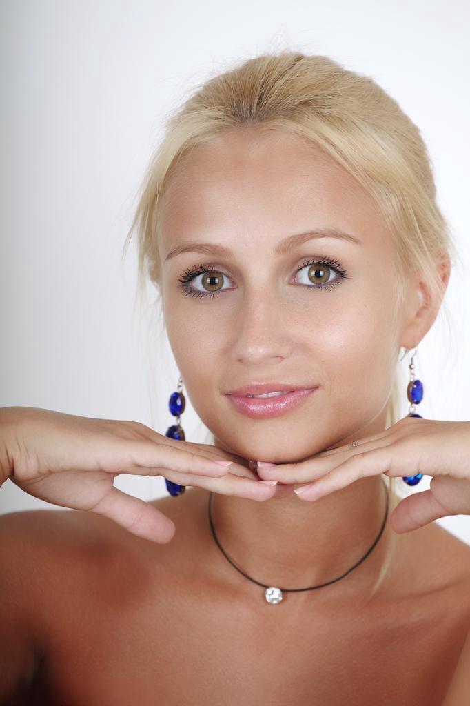 Natural blonde Afina blows a kiss after confidently modeling in the nude