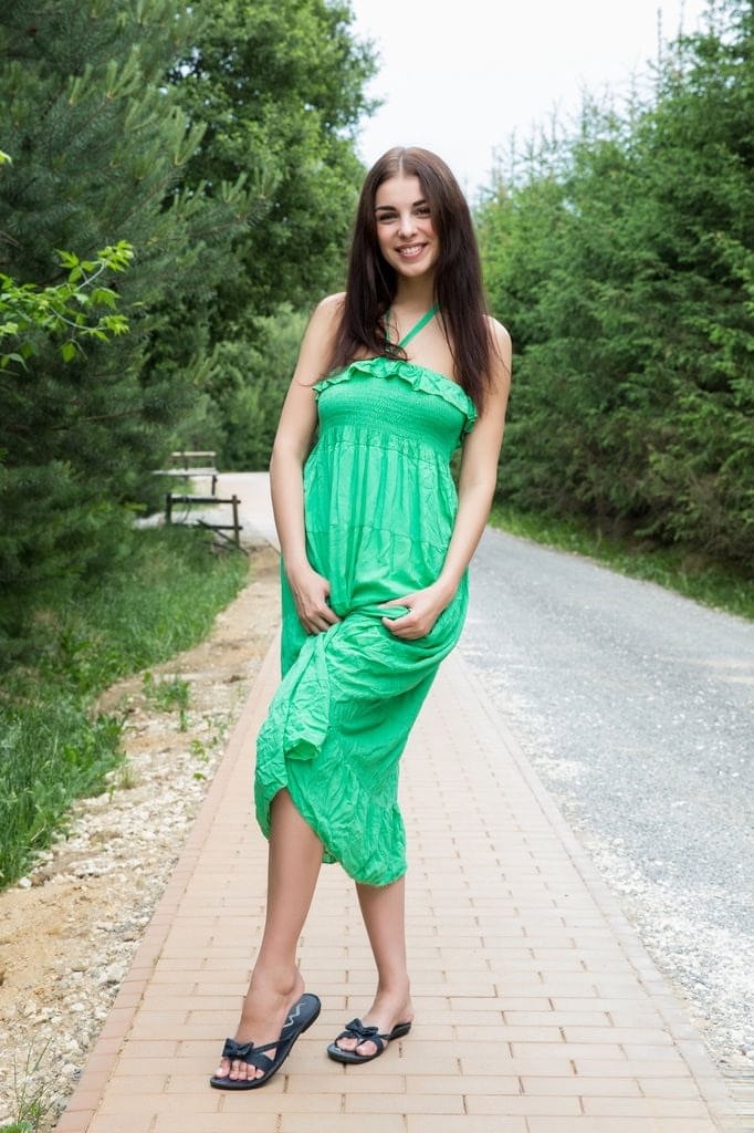 Naughty brunette Evita Lima flashes a naked upskirt then strips in the roadway