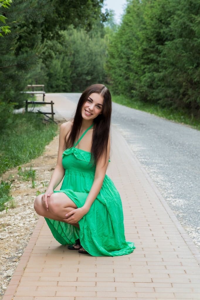 Naughty brunette Evita Lima flashes a naked upskirt then strips in the roadway