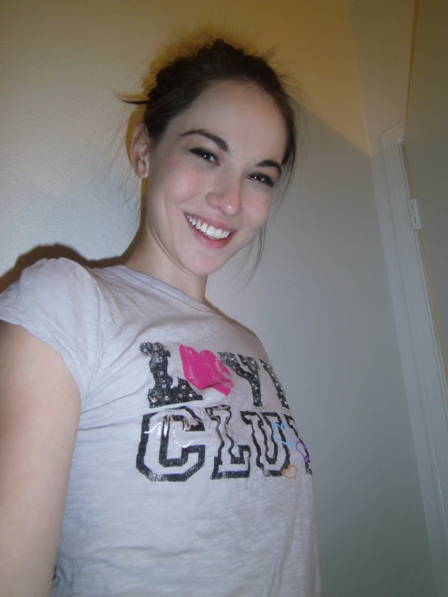 Cute brunette Emily undressing to take self shots of her bare tits and hot ass