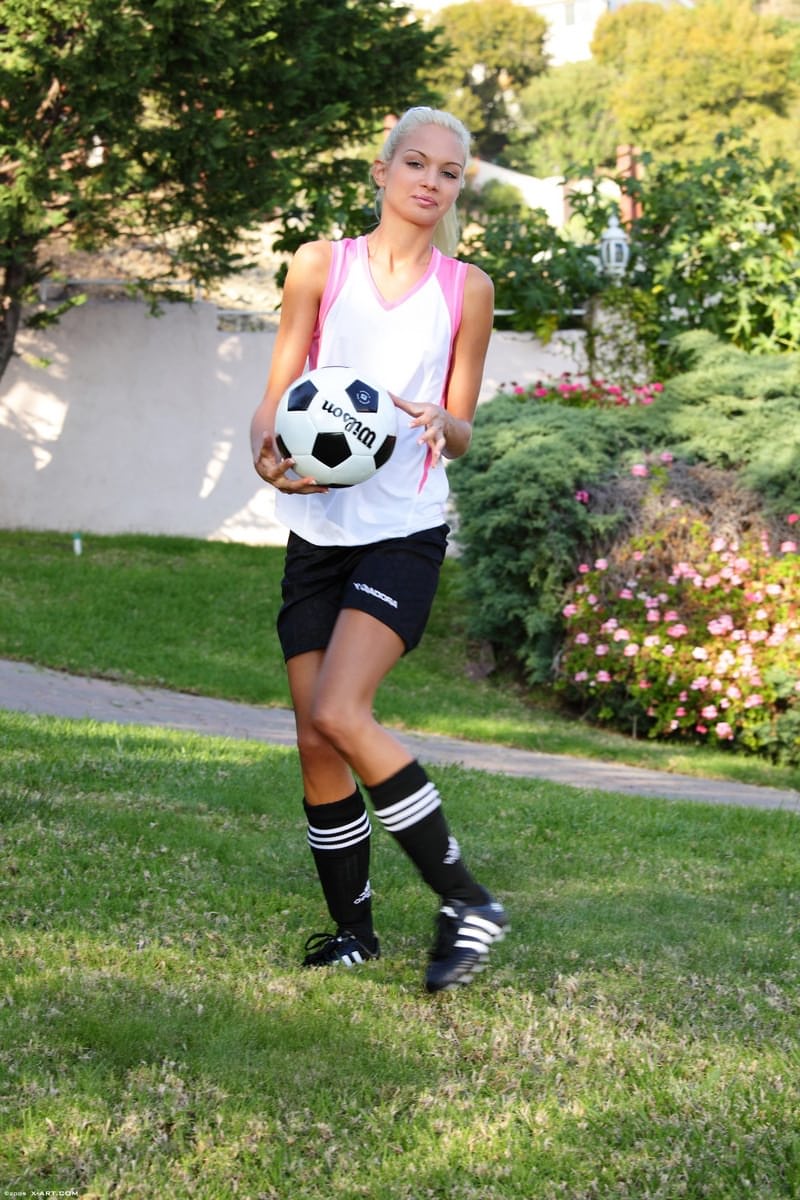 Skinny blonde girl uncovers tiny tits while bouncing a soccer ball outdoors
