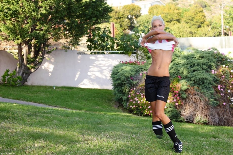 Skinny blonde girl uncovers tiny tits while bouncing a soccer ball outdoors