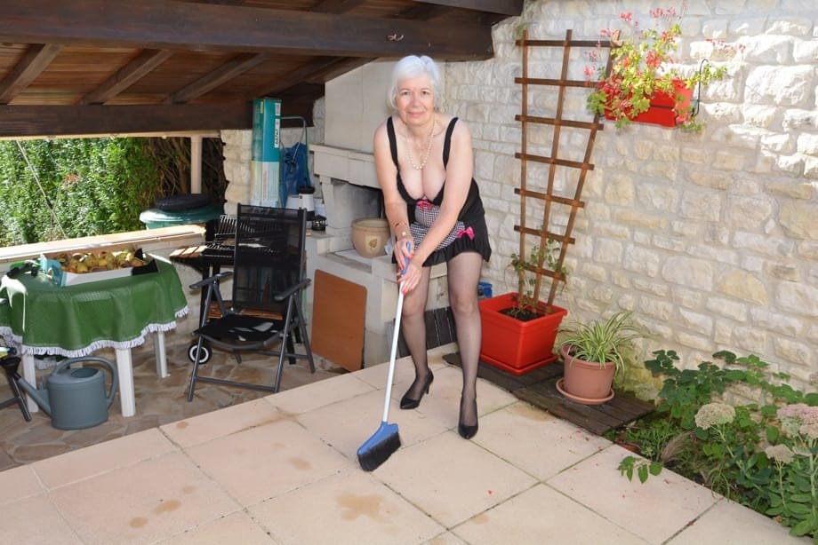 Horny granny lifts her sexy skirt to play with her beaver in the garden