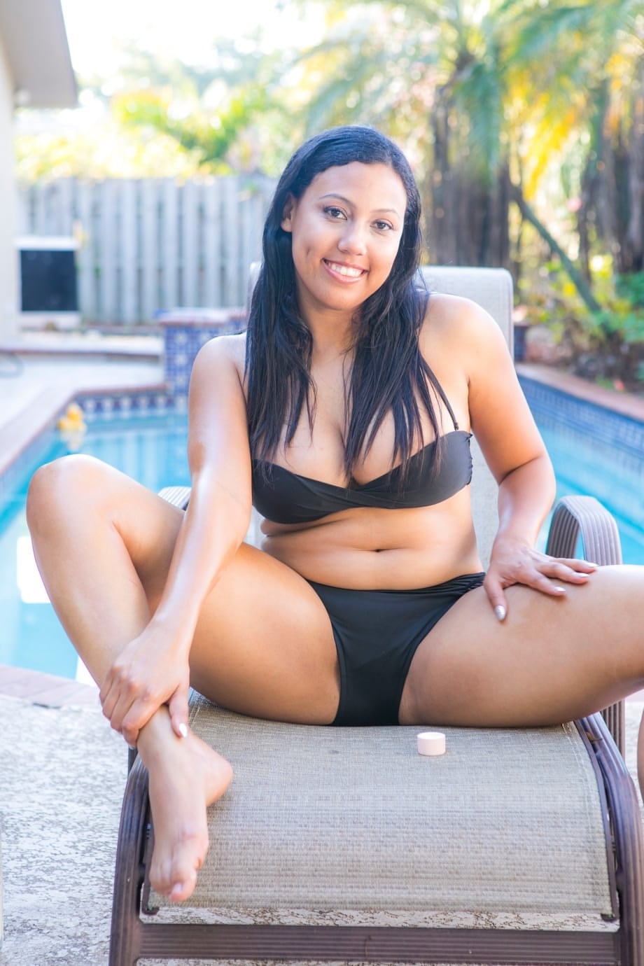 Chubby black amateur removes her bikini to pose nude on chair by a pool