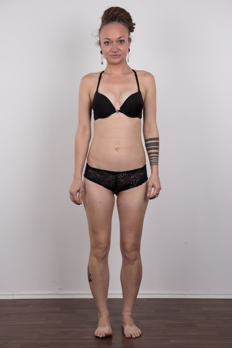 Pierced and tattooed amateur Petra stands naked after removing her clothes