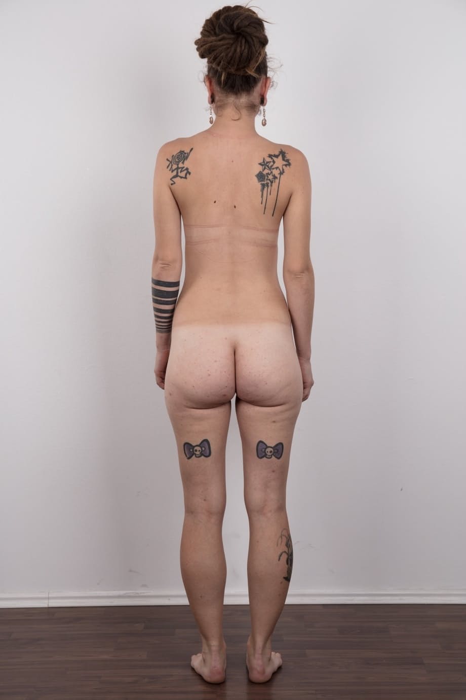 Pierced and tattooed amateur Petra stands naked after removing her clothes