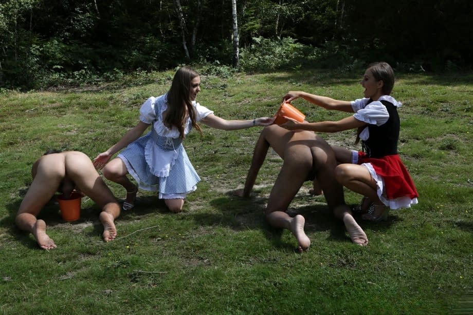 Horny femdom girls in costume head to the field to milk their naked man slave