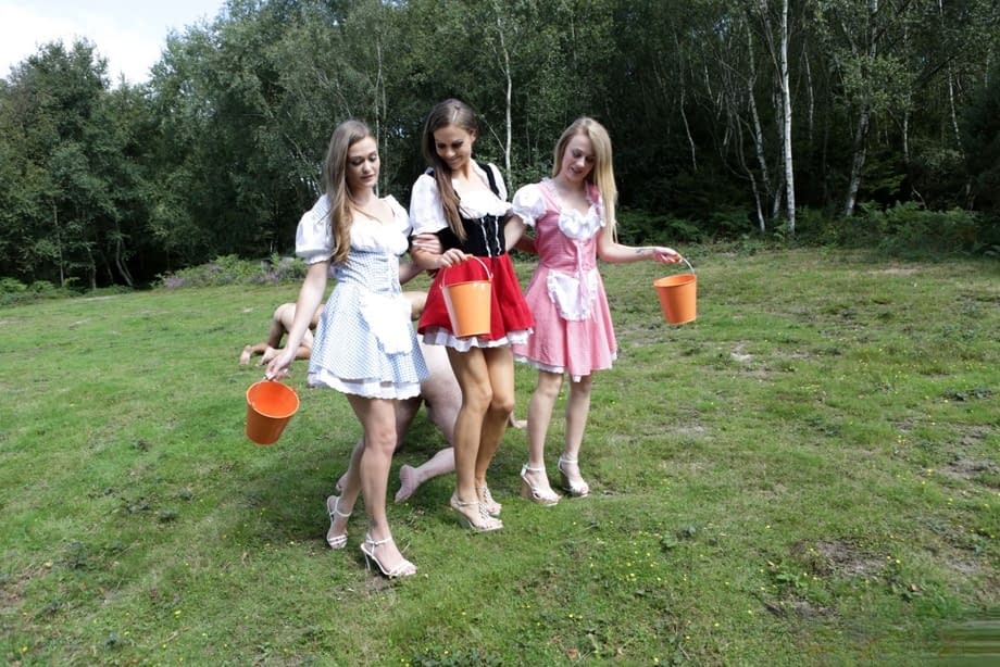 Horny femdom girls in costume head to the field to milk their naked man slave