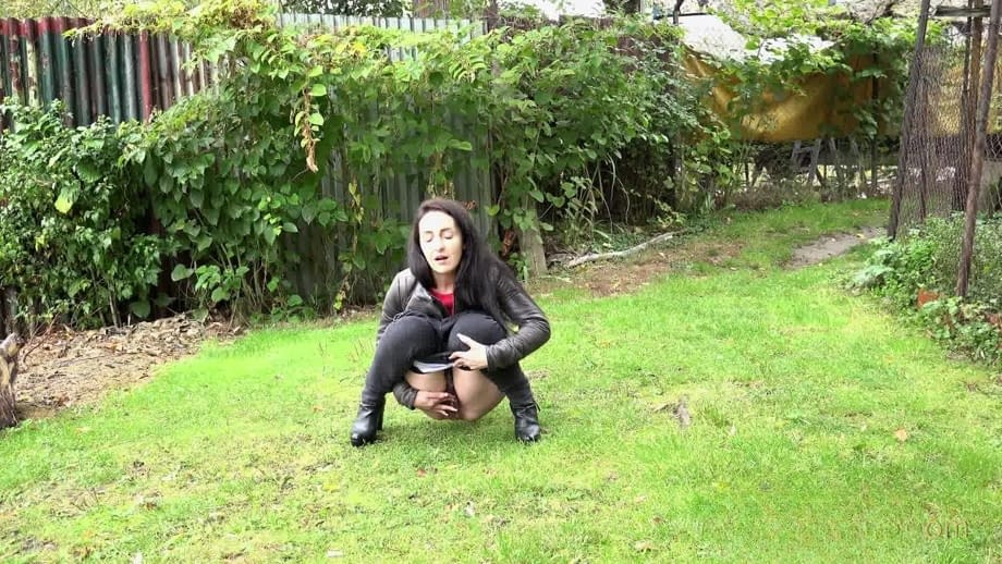 Long haired Corin bares her hairy pussy while taking a pee on the grass