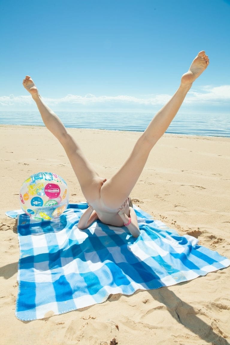 Barely legal teen gets naked atop a blanket at the beach