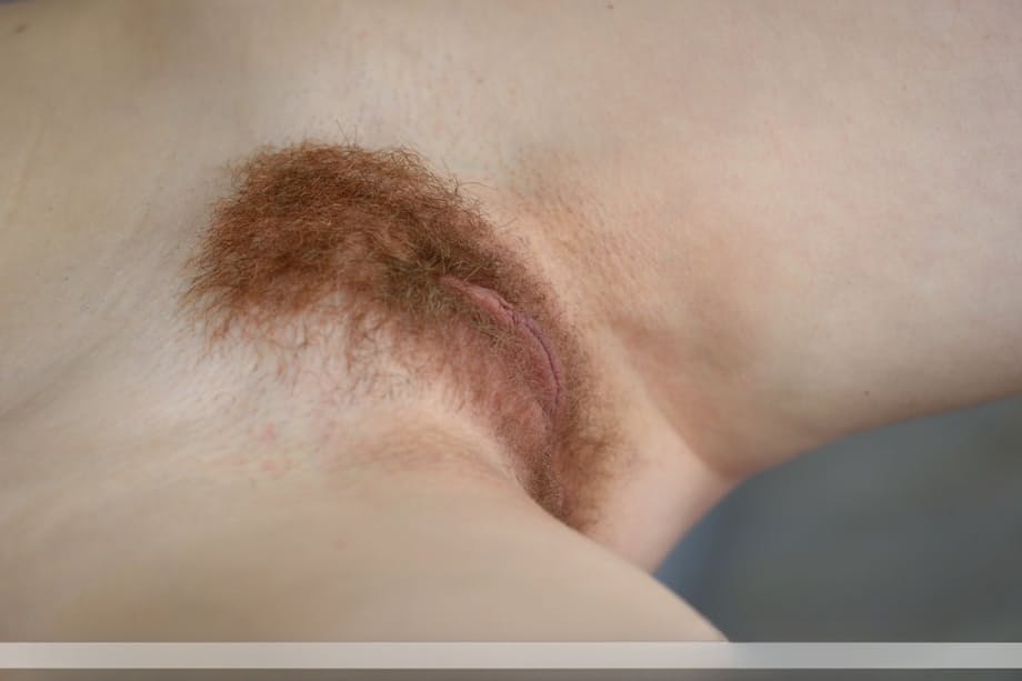 Beautiful redhead Adel P lounging naked showing off her hairy pussy close up