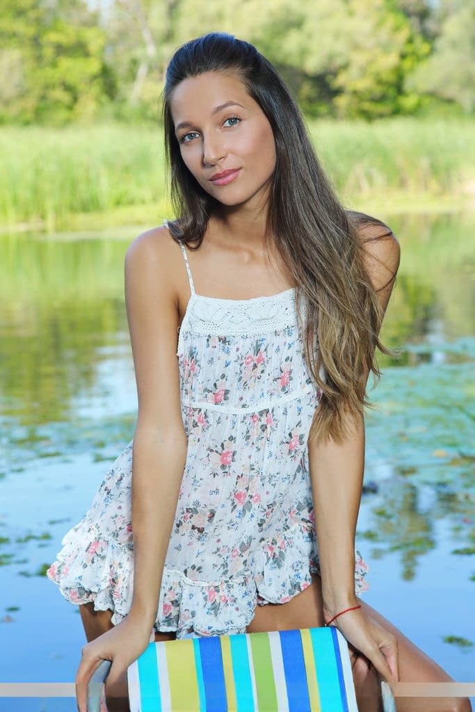 Teen solo girl strikes nude poses in the middle of a slow moving stream