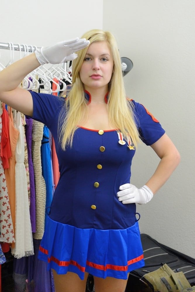 Busty blonde Danielle flashes her big tits and bald pussy in the uniform shop