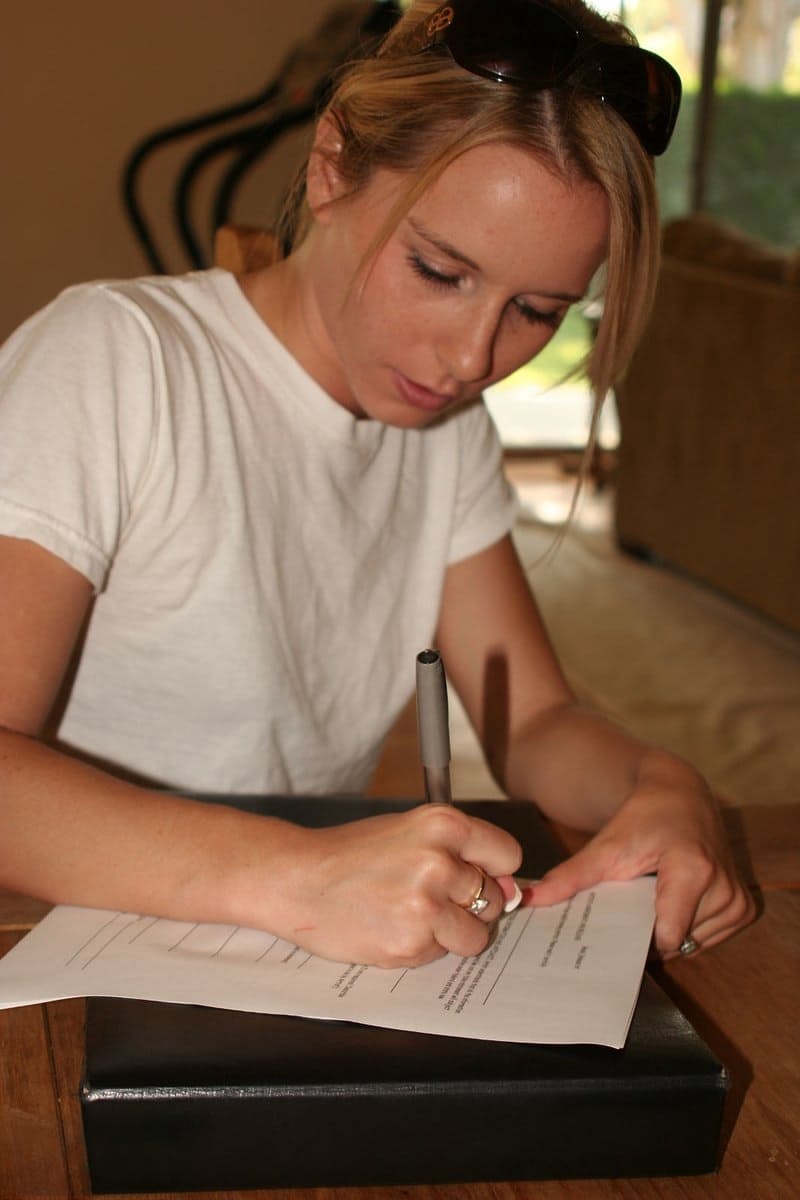 Young blonde stands naked before signing nude model release forms