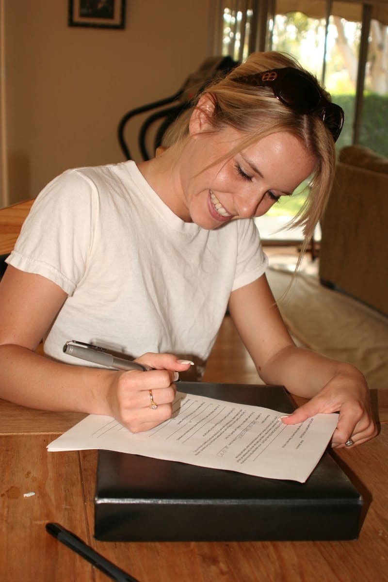 Young blonde stands naked before signing nude model release forms