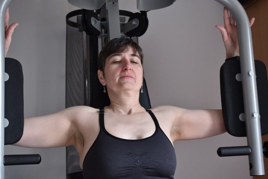 Fit older lady shows off her saggy tits while working out at the gym