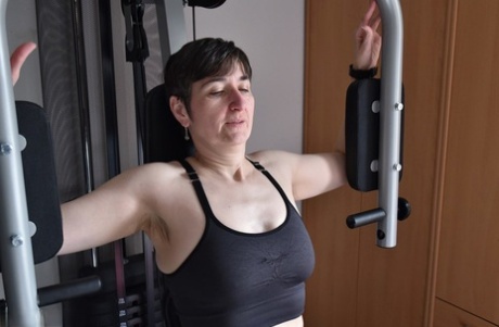 Fit older lady shows off her saggy tits while working out at the gym