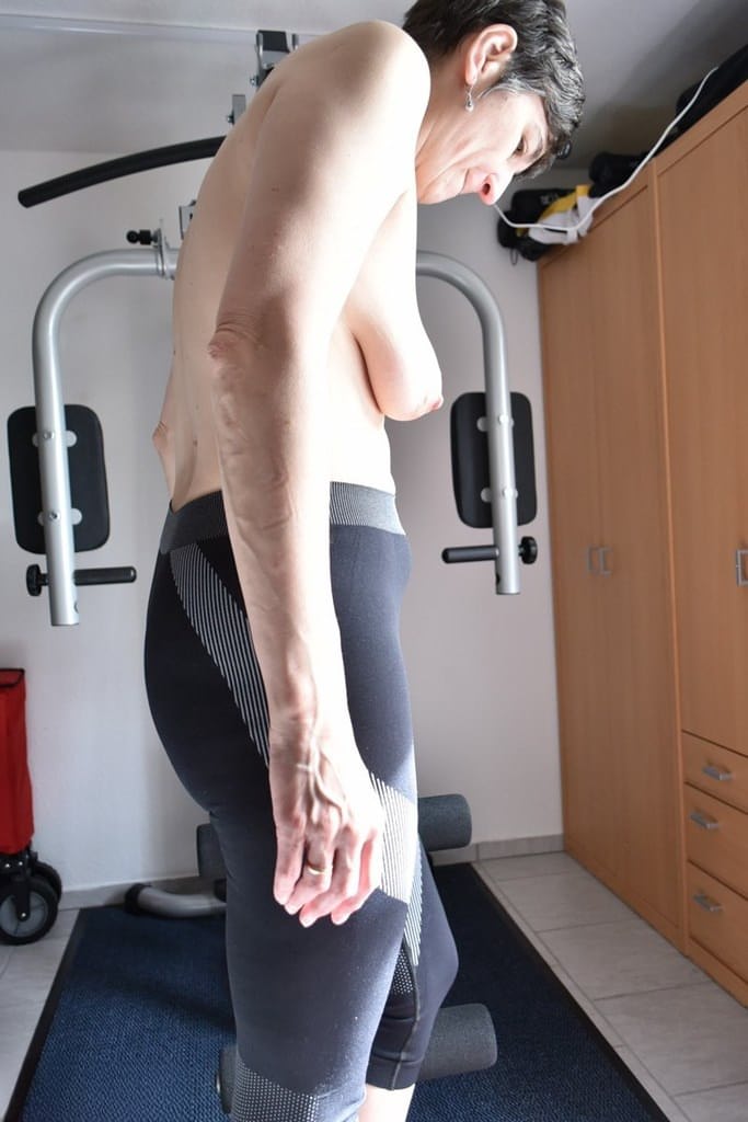 Fit older lady shows off her saggy tits while working out at the gym