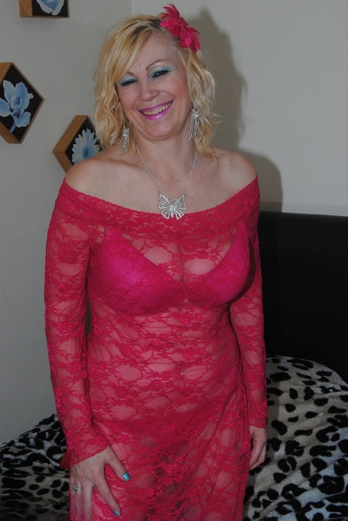 Mature sexy Platinum Blonde pulls down red lace dress to expose big saggy tits