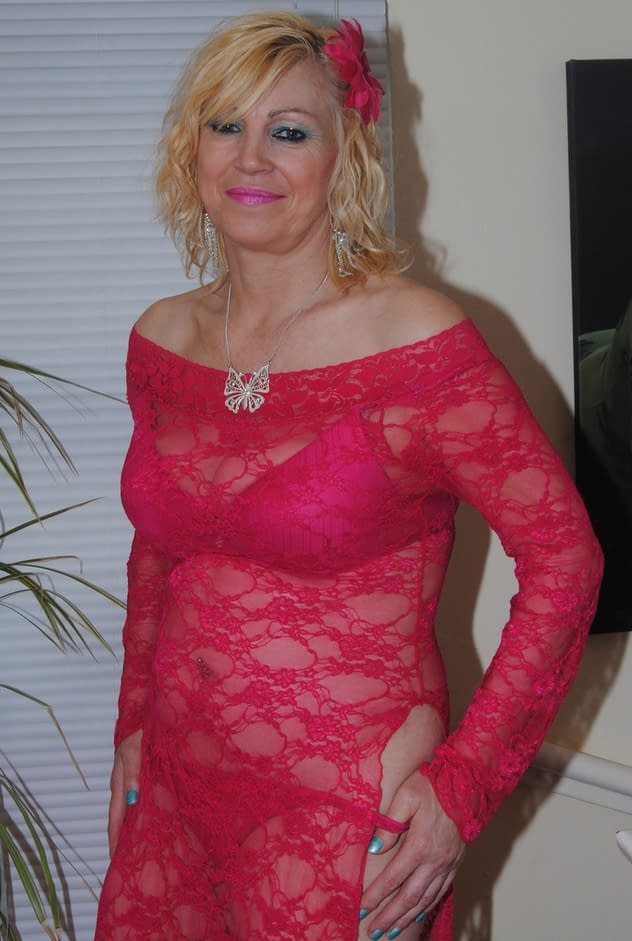 Mature sexy Platinum Blonde pulls down red lace dress to expose big saggy tits