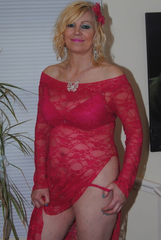 Mature sexy Platinum Blonde pulls down red lace dress to expose big saggy tits