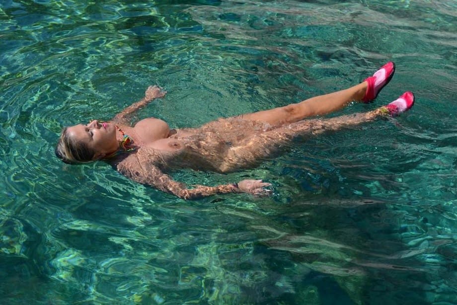 Busty blonde Chrissy pilots her speed boat nude to sun her thick naked body