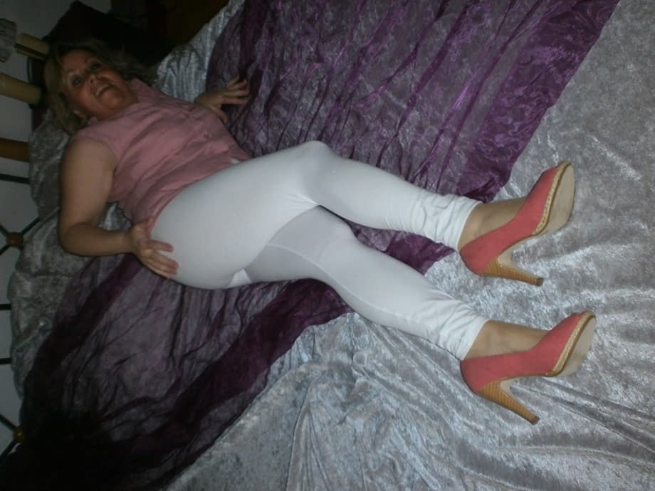 Mature woman Caro slides her white leggings over her granny panties