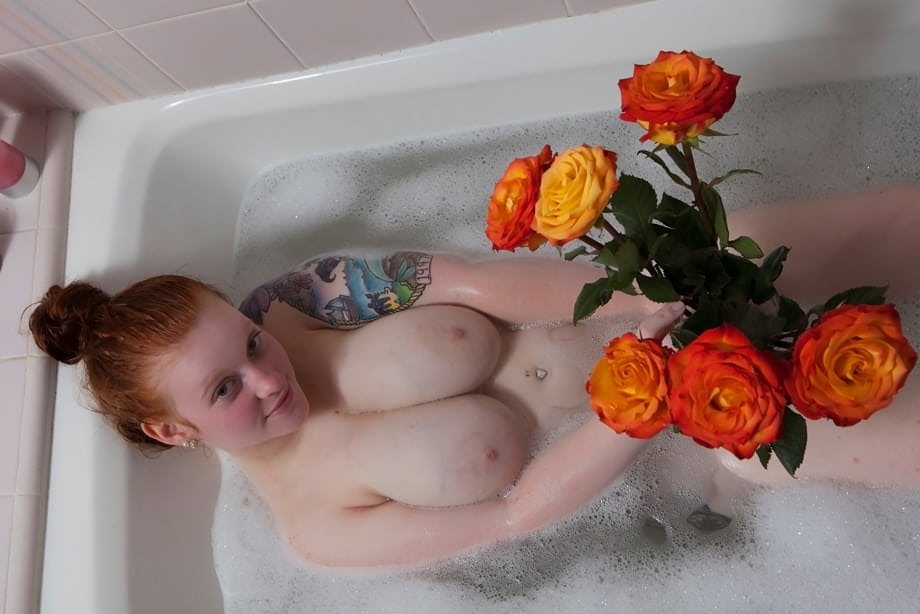Pale redhead Kaycee Barnes displays her large boobs and butt during a bath