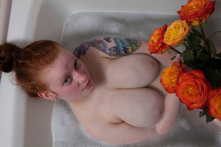 Pale redhead Kaycee Barnes displays her large boobs and butt during a bath