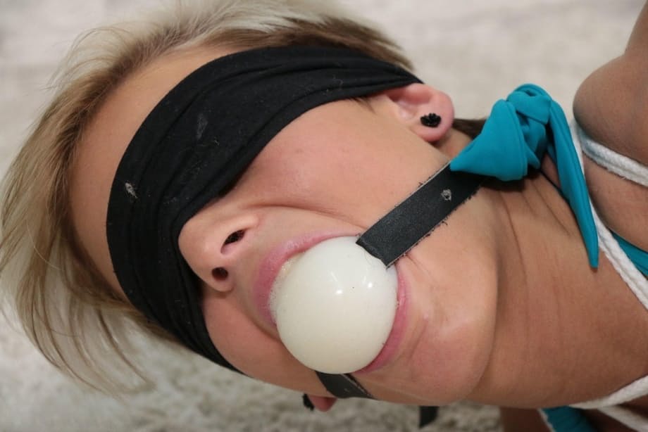 Short haired girl is ballgagged and hogtied in bare feet and a bikini