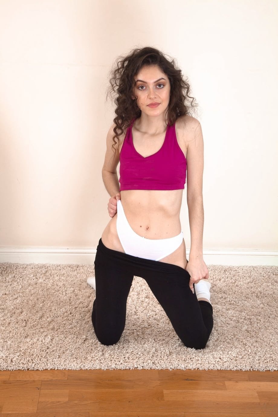 Slim brunette uncovers her tiny tits before showing her full bush