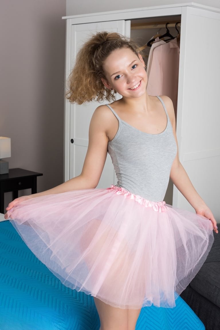 Tiny teen Faina removes tutu and onesie to model naked on her bed
