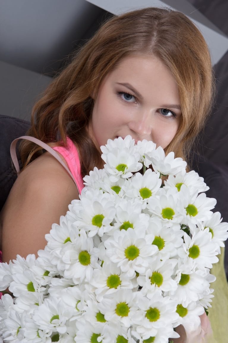 Cute teen Eveline frees her puffy pussy from panties with a daisy in her hair