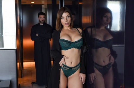 Brunette chick covers up her naked boobs in front of a Priest
