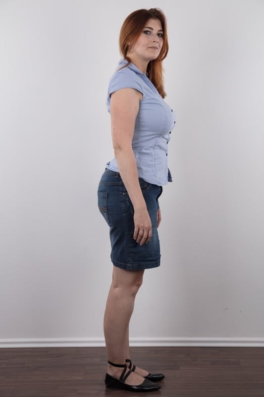 Overweight redhead Eva stands straight while clothed and totally naked too