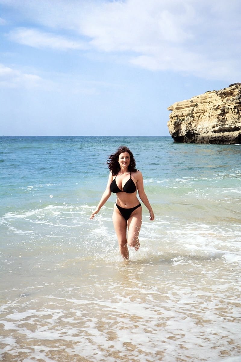 Brunette MILF Lorna Morgan releases her nice melons from bikini on a beach
