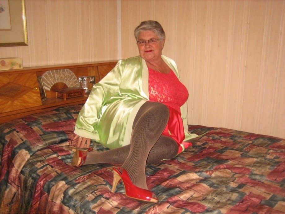 Fat granny Girdle Goddess pets her pussy after stripping to hosiery on her bed