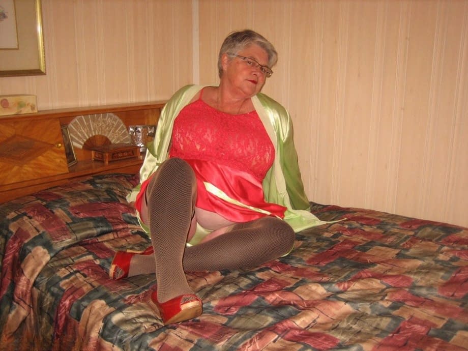 Fat granny Girdle Goddess pets her pussy after stripping to hosiery on her bed