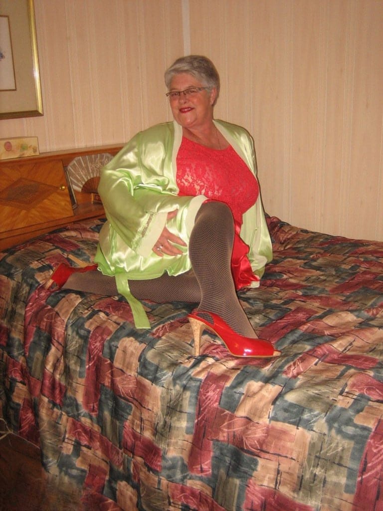 Fat granny Girdle Goddess pets her pussy after stripping to hosiery on her bed